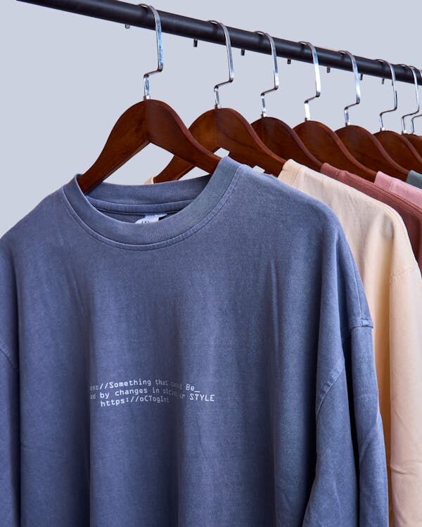 Free Close-up of various colorful sweaters on hangers with printed text, suitable for fashion concepts. 